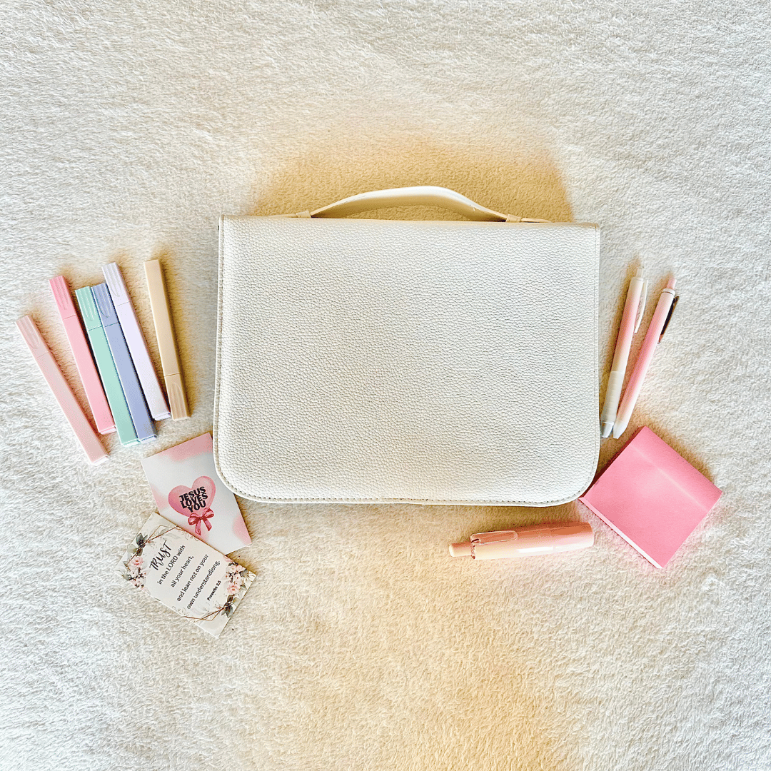 White Bible cover with pastel markers, a pink sticky note and correction tap roller for bible studies