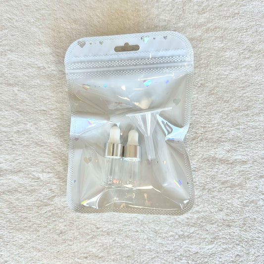 Two small anointing oil bottles with a funnel